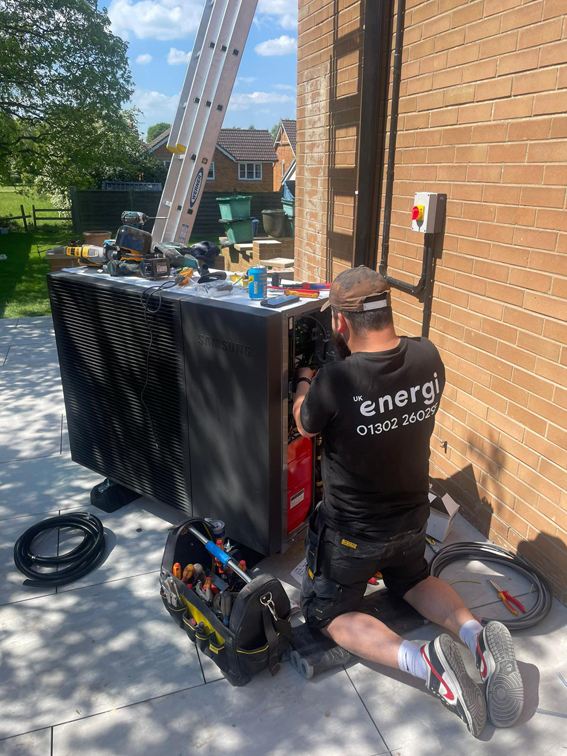 Installer working on an air source heat pump fan