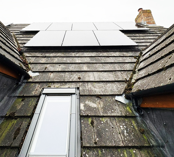 A roof and velux window with solar panels fitted above