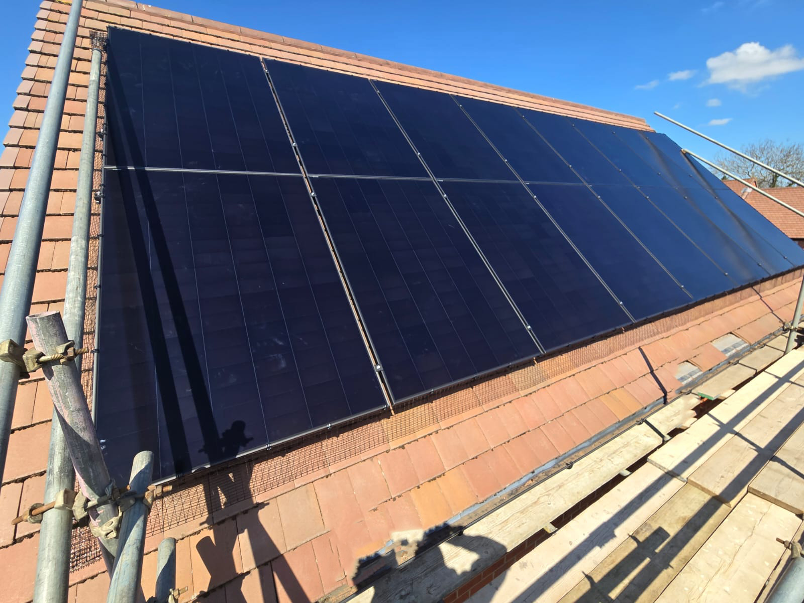 14 black solar panels fitted on a sloping roof