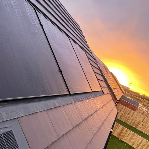 Solar Panel Installation along a roof with Sunset in background